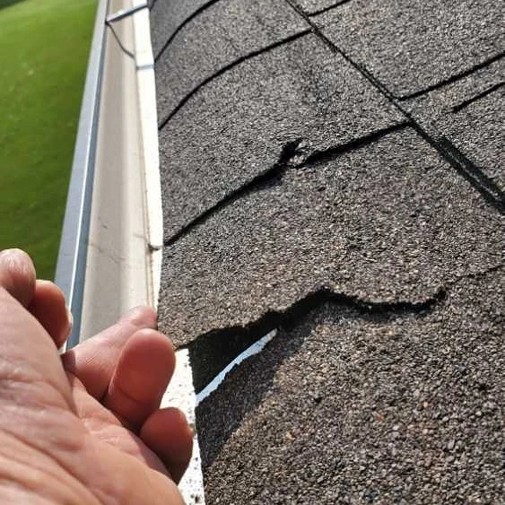 Shingles are damaged from wind or installation. Home Inspection by Powerworks Inspections