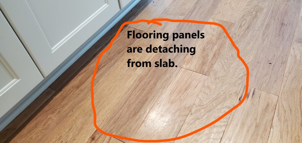 Hardwood flooring is detaching from the subfloor as a result of the glue or slab configuration. . This was discovered by Powerworks Inspections during a 11-Month Warranty home inspection.