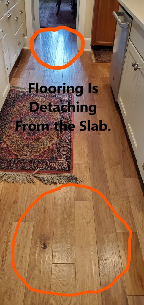 Hardwood flooring is detaching from the subfloor as a result of the glue or slab configuration. . This was discovered by Powerworks Inspections during a 11-Month Warranty home inspection.